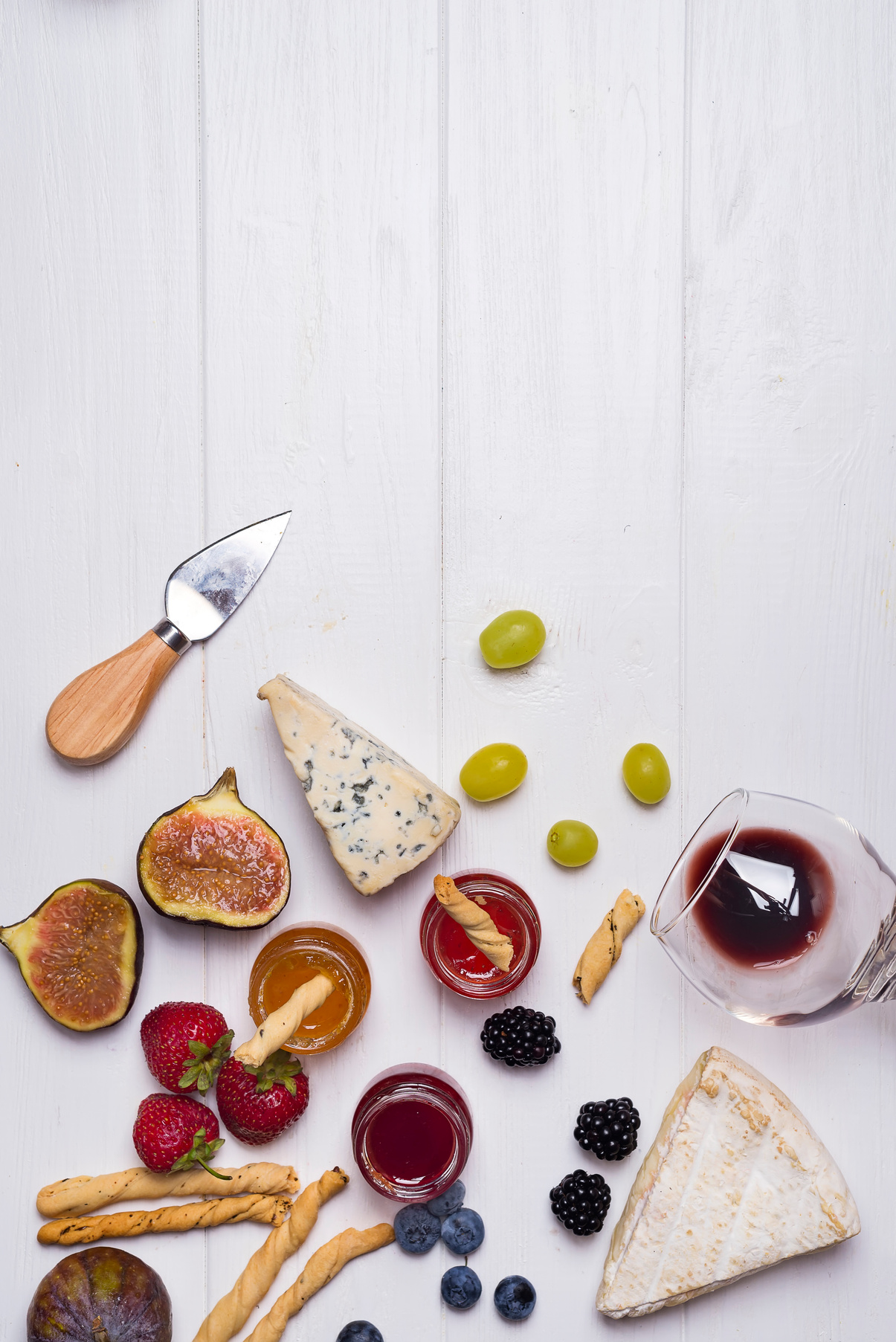 Winery Concept with Cheese and Fruits on White Wooden Background